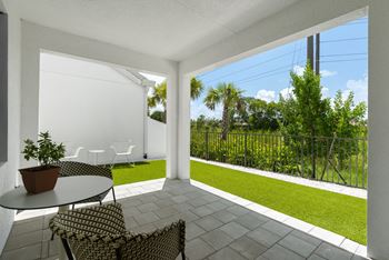 a patio with two chairs and a table and a lawn at Odyssey, Florida